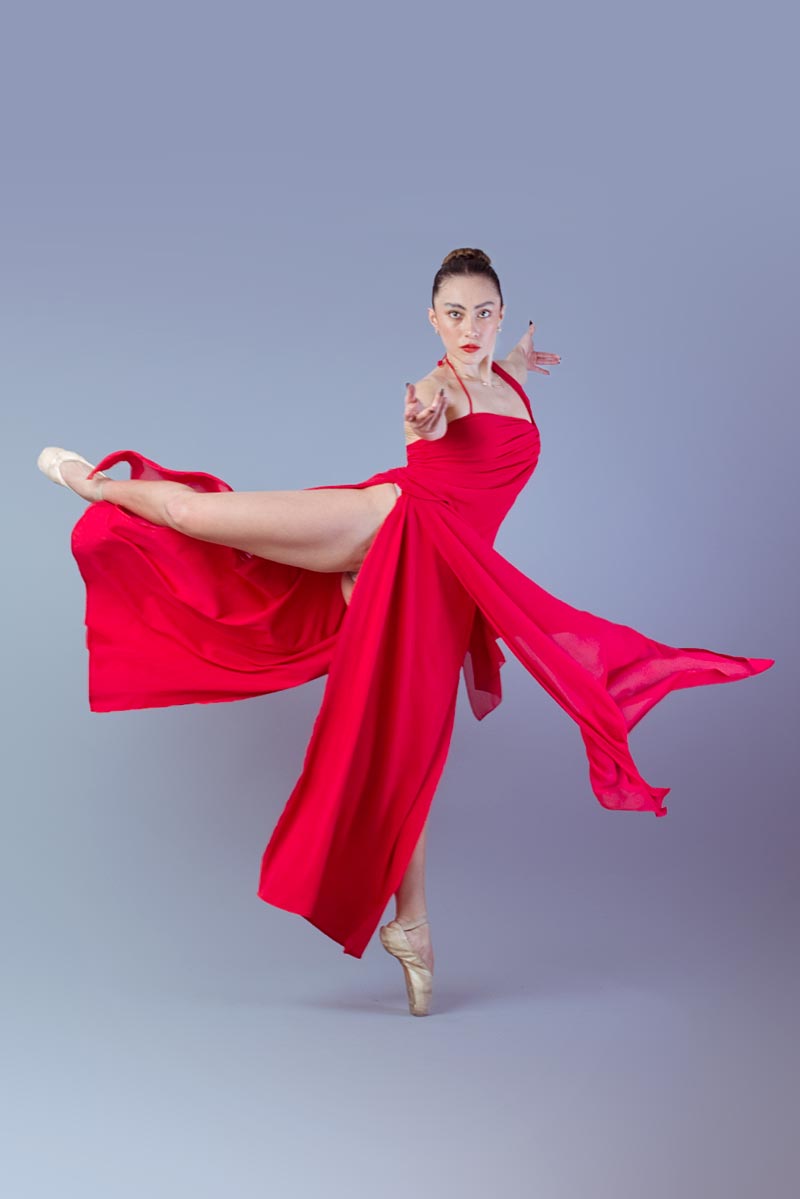 Llublyn Ponce con vestido rojo en salto dinámico con pierna extendida y brazos al frente, mirada intensa a cámara, sesión de moda editorial CDMX, fotografía por Josué Palma